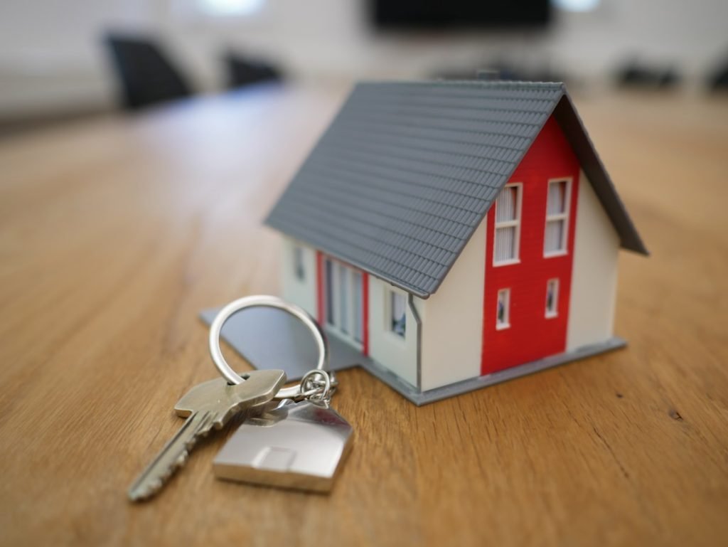 Model house with a set of keys on a wooden table