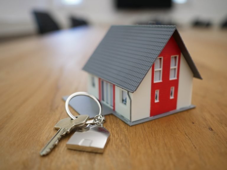 Model house with a set of keys on a wooden table